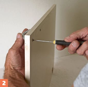 Måla köksluckor själv: Skruva av luckans handtag med en skruvmejsel. Måla köksluckor själv: Skruva av luckans handtag med en skruvmejsel.